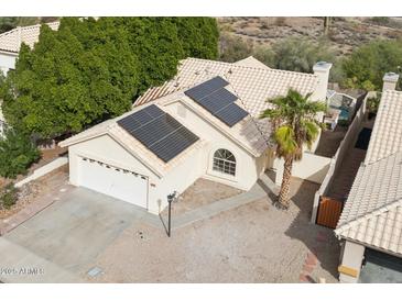 Single-story home with solar panels, a two-car garage, and a desert landscape at 12075 N 110Th St, Scottsdale, AZ 85259