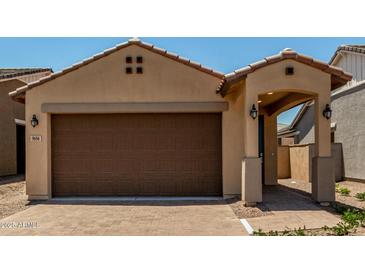 Inviting single-story home featuring a two-car garage, covered entryway, and desert landscaping at 5656 N 205Th Ln, Buckeye, AZ 85396