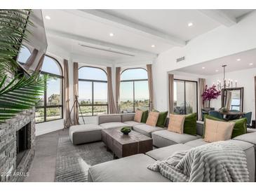 Spacious living room with large windows showcasing scenic views and a comfortable, oversized sectional at 3800 E Lincoln Dr # 23, Phoenix, AZ 85018