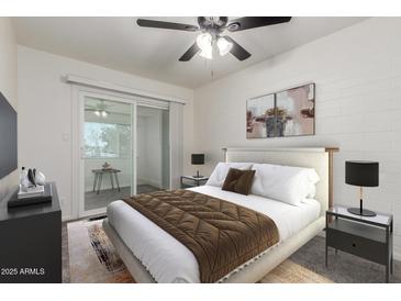 Bright bedroom with a sliding glass door, plush bedding, and contemporary décor at 2608 W Berridge Ln # 220, Phoenix, AZ 85017