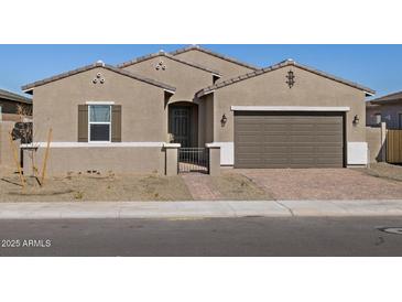 Inviting single-story home featuring a two-car garage and a secure gated front entrance at 17672 W Pierson St, Goodyear, AZ 85395