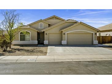 Inviting single-story home featuring a three-car garage and well-maintained landscaping at 43205 W Askew Dr, Maricopa, AZ 85138