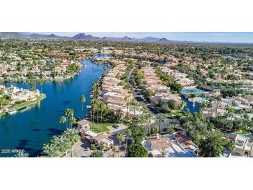 Stunning aerial view of waterfront homes, lush landscaping, and resort-style amenities in a desirable lakeside community at 10063 E Cinnabar Ave, Scottsdale, AZ 85258