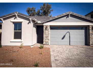 Charming single-story home featuring a stone-accented facade and a well-maintained, neutral-toned exterior at 5414 W Las Palmaritas Dr, Glendale, AZ 85302