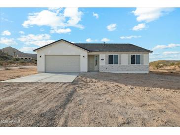 Charming single-story home featuring a two-car garage and low-maintenance desert landscaping at 13634 S 192Nd Ave, Buckeye, AZ 85326