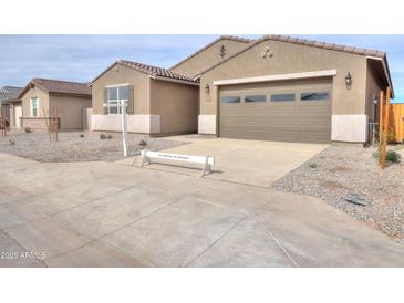 Charming single-story home featuring a two-car garage, desert landscaping, and neutral-toned exterior at 36834 W La Paz St, Maricopa, AZ 85138