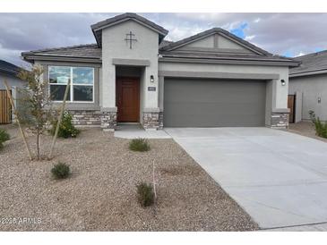 One-story home with a two-car garage and desert landscaping at 492 W Freedom St, Florence, AZ 85132