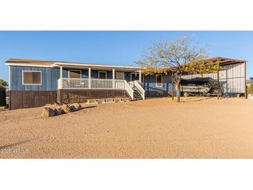 Charming blue house with a covered porch, boat carport, and desert landscaping at 10120 E Mclellan Rd, Mesa, AZ 85207