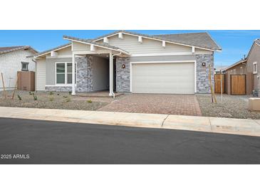 Charming single-story home featuring stone accents, a brick driveway, and a two-car garage at 44713 N 44Th Dr, Phoenix, AZ 85087