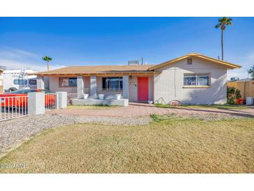 Charming single story home with red front door and grassy yard at 1931 N Macdonald --, Mesa, AZ 85201