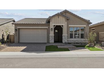 Charming single-story home featuring stone accents, a two-car garage, and well-maintained landscaping at 32994 N 131St Dr, Peoria, AZ 85383