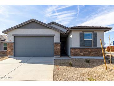 Charming single-Gathering home featuring stone accents, a gray garage door, and desert landscaping at 8584 N 170Th Ln, Waddell, AZ 85355