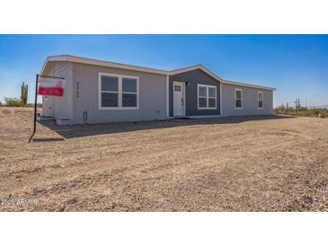 Charming single-story home featuring a light gray exterior and well-maintained desert landscaping at 41735 N 260Th Ave, Morristown, AZ 85342