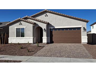 Charming single-story home featuring a brick driveway and a two-car garage at 17586 W Blue Sky Dr, Surprise, AZ 85387