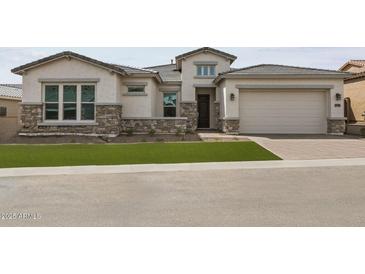 Beautiful single Gathering home with stone accents, manicured lawn, and welcoming curb appeal at 21627 W Mariposa St, Buckeye, AZ 85396