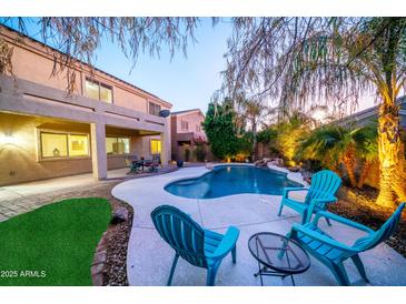 Inviting backyard oasis with a sparkling pool, lush landscaping, and relaxing patio furniture at 23914 N 25Th Way, Phoenix, AZ 85024