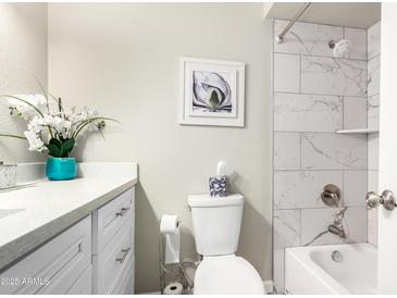 Bright bathroom featuring updated shower with marble tile, vanity with white countertop, and modern fixtures at 4329 W Sierra St, Glendale, AZ 85304