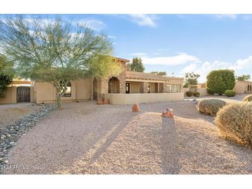 Front view of a charming single-story home with stone accents and a landscaped yard at 7341 E Sutton Dr, Scottsdale, AZ 85260