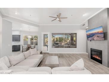 Spacious living room featuring hardwood floors, fireplace, and large window at 32427 N 71St Way, Scottsdale, AZ 85266