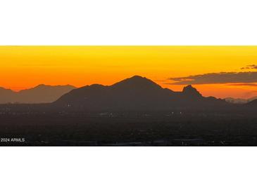 Stunning sunset view over city lights and mountain silhouettes at 13503 E Charter Oak Dr, Scottsdale, AZ 85259