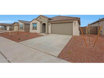 Charming single-story home with a tile roof, two-car garage, and low maintenance desert landscaping at 17316 W Via Dona Rd, Surprise, AZ 85387