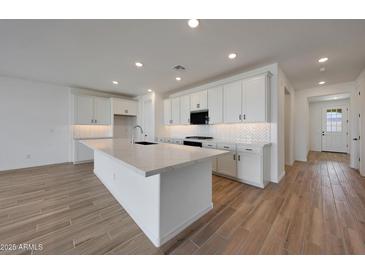 Well-lit kitchen featuring a spacious island and modern white cabinetry at 17316 W Via Dona Rd, Surprise, AZ 85387