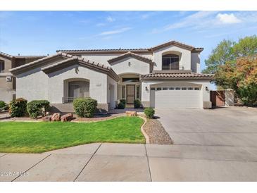 Two-story stucco home featuring a manicured lawn, two-car garage, and desert landscaping at 2264 S Sorrelle --, Mesa, AZ 85209