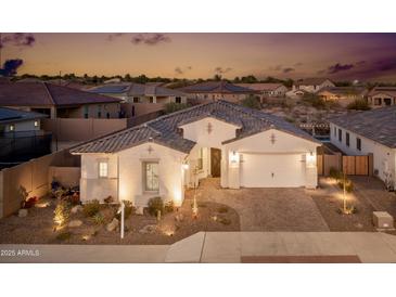 Stunning curb appeal featuring a two-car garage and desert landscaping at 2453 N 211Th Ln, Buckeye, AZ 85396