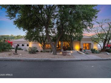 Stunning desert landscaping surrounds this single-level home with a three-car garage at 1535 E Calavar Dr, Phoenix, AZ 85022