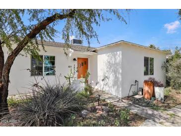 Charming single story home with a well-manicured front yard and orange door at 3844 N 13Th Ave, Phoenix, AZ 85013