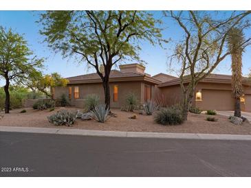 Desert landscape surrounds this single-story home with a neutral facade at 7479 E Sunset Sky Cir, Scottsdale, AZ 85266