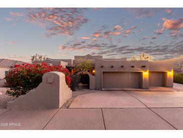Stunning home exterior with a two car garage, mature landscaping, and a beautiful desert sunset at 15155 E Westridge Dr, Fountain Hills, AZ 85268