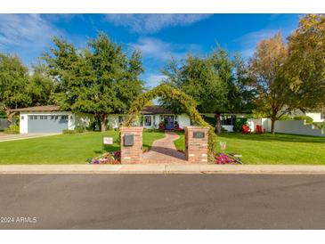 Beautiful home exterior with lush landscaping and brick walkway at 6030 E Calle Del Sud St, Scottsdale, AZ 85251