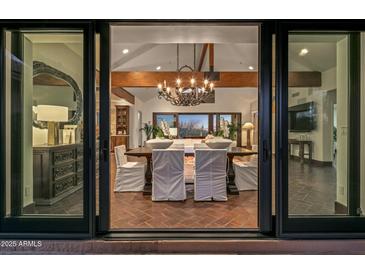 Elegant dining room with a chandelier and view to backyard at 9515 E Sundance Trl, Scottsdale, AZ 85262