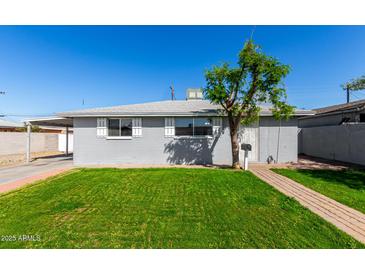 Charming single-story home with a well-maintained lawn and lovely tree providing curb appeal at 6414 W Osborn Rd, Phoenix, AZ 85033