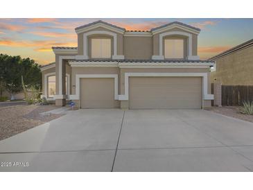 Two-story house with tan exterior, two-car garage, and landscaping at 9131 W Albert Ln, Peoria, AZ 85382