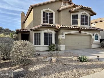 Two-story house with tan exterior, landscaped yard, and attached garage at 20436 N 17Th Pl, Phoenix, AZ 85024