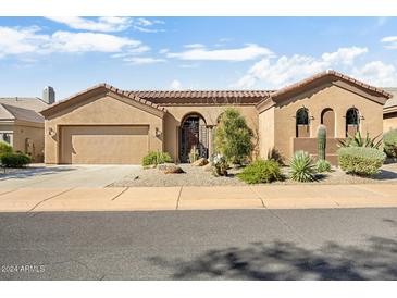 Single-story home with desert landscaping, two-car garage, and gated entry at 34704 N 93Rd Pl, Scottsdale, AZ 85262