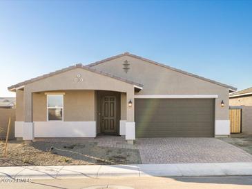 Charming single-story home with a brick driveway, two-car garage, and neutral color scheme at 17731 W Elm St, Goodyear, AZ 85395