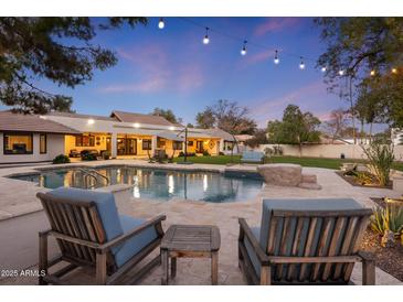 Relaxing backyard oasis with a sparkling pool, patio furniture, and string lights at 2031 E La Vieve Ln, Tempe, AZ 85284