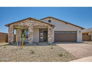 Charming single-story home featuring stone accents, a two-car garage, and a well-maintained gravel front yard at 25353 N 176Th Ave, Surprise, AZ 85387