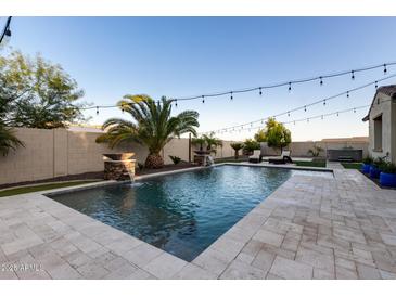 Inviting swimming pool with stone patio and fire features at 20404 W Crescent Dr, Buckeye, AZ 85396