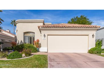 Tan stucco house with a tile roof, two-car garage, and nicely landscaped front yard at 8062 E Cortez Dr, Scottsdale, AZ 85260