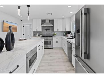 Modern kitchen with white cabinets, marble countertops, and stainless steel appliances at 11615 N 30Th St, Phoenix, AZ 85028