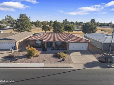 Single story home with tile roof, two-car garage, and landscaped yard at 4047 E Catalina Cir, Mesa, AZ 85206