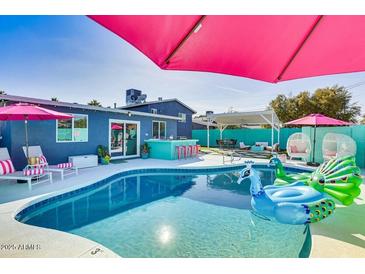 Inviting backyard oasis with a sparkling pool, patio, and vibrant landscaping at 602 E Taylor St, Tempe, AZ 85288
