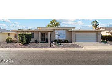 Tan mid-century modern home with carport and small front yard at 10515 W Oak Ridge Dr, Sun City, AZ 85351