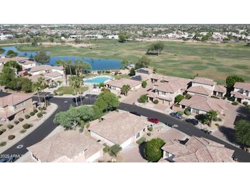 An aerial view showcases a community with a pool, lake, golf course, and well-maintained landscaping at 13613 W Cypress St, Goodyear, AZ 85395
