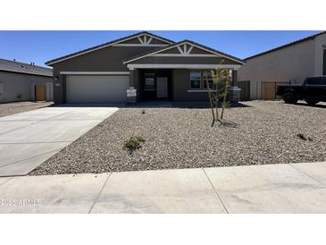 Inviting single-story home featuring a well-manicured gravel yard, attached garage, and classic architectural details at 47267 W Mellen Ln, Maricopa, AZ 85139