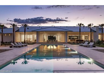 Luxury home showcases a serene backyard pool, lounge chairs, and sleek modern architecture at twilight at 6215 N Casa Blanca Dr, Paradise Valley, AZ 85253